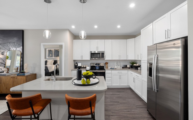 Kitchen with large island and stools with stainless steel appliances 