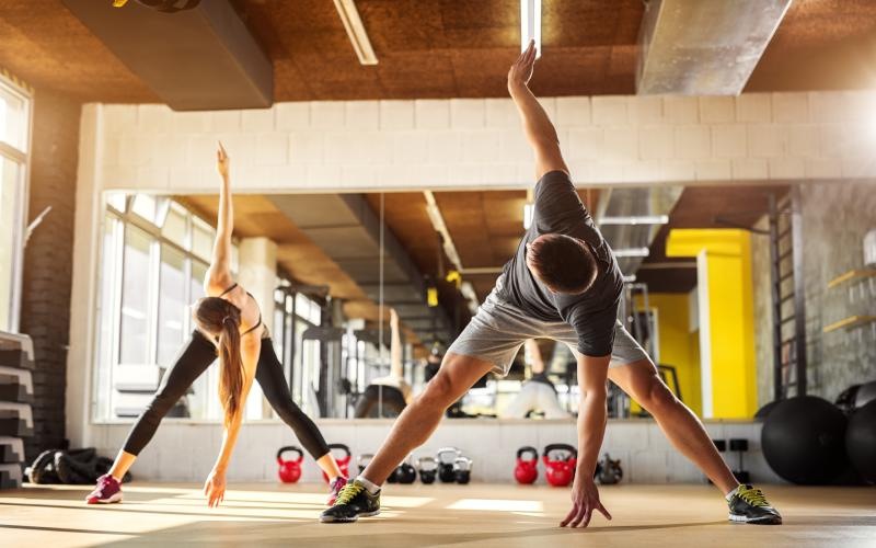 a man and woman exercising in a gym